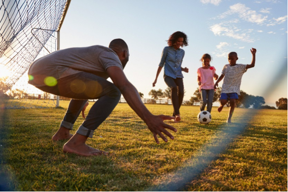 Family-of-Four-Playing-Soccer-Outside Family of four playing soccer outside